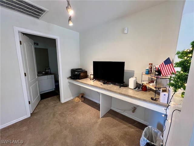 carpeted home office featuring built in desk