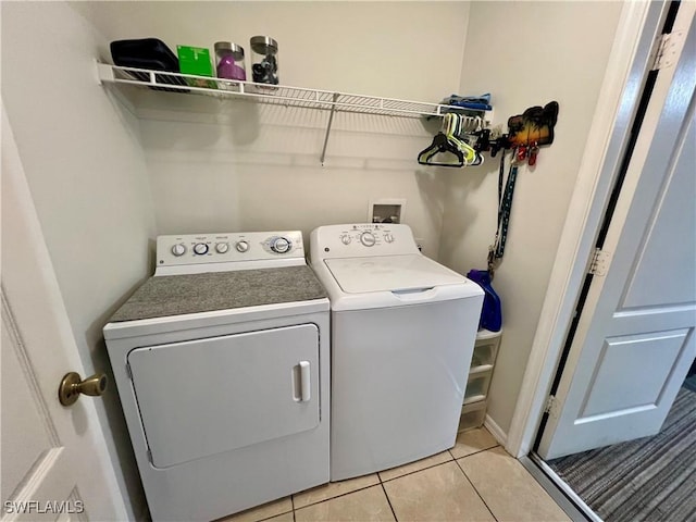 washroom featuring light tile patterned flooring and washing machine and dryer