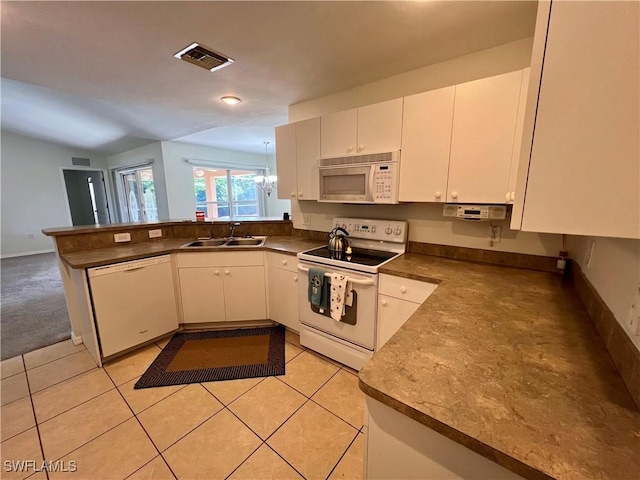 kitchen featuring white cabinetry, sink, white appliances, and kitchen peninsula