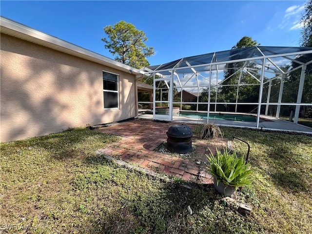 view of yard with a patio area, a lanai, and an outdoor fire pit