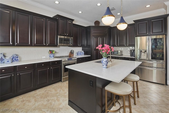 kitchen featuring sink, backsplash, hanging light fixtures, stainless steel appliances, and a center island