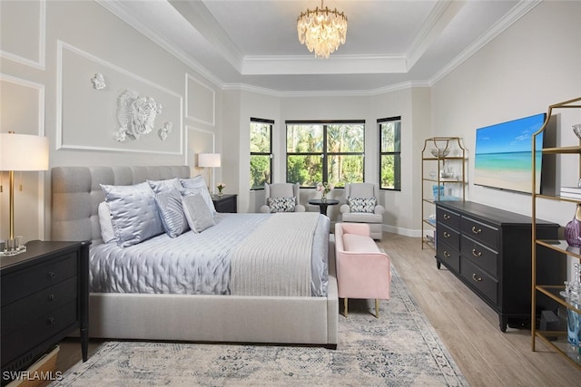 bedroom featuring crown molding, a notable chandelier, a tray ceiling, and light wood-type flooring