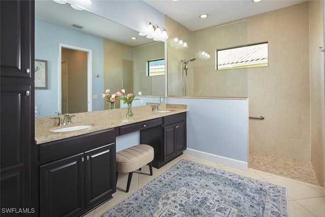 bathroom featuring vanity, tile patterned floors, and tiled shower