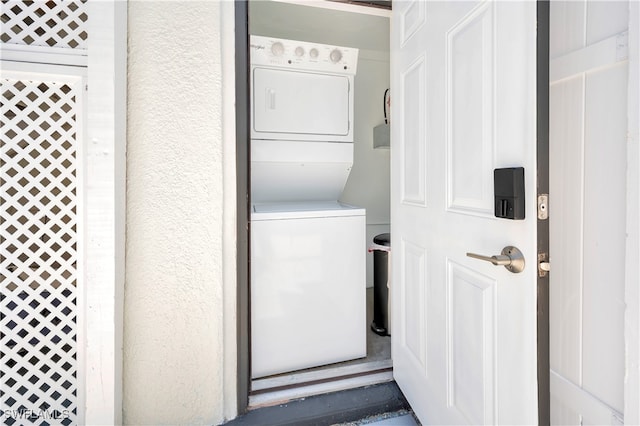 clothes washing area with stacked washer and dryer