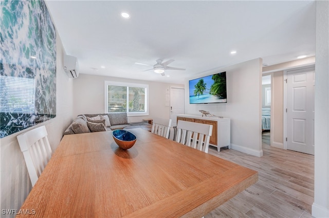 dining area featuring ceiling fan, light hardwood / wood-style floors, and a wall unit AC