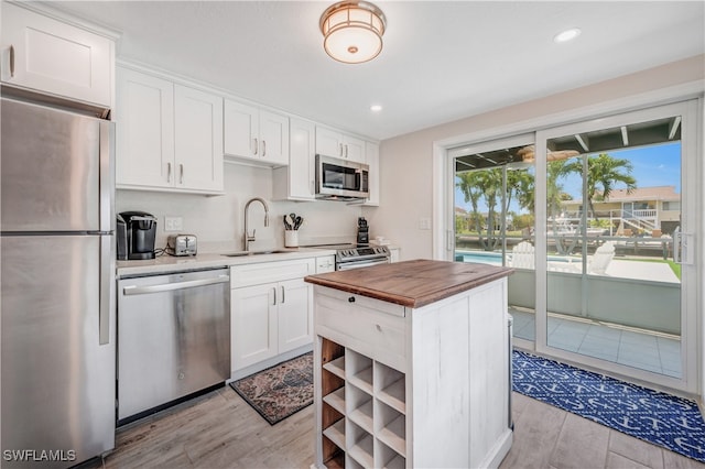 kitchen featuring white cabinetry, appliances with stainless steel finishes, sink, and a wealth of natural light