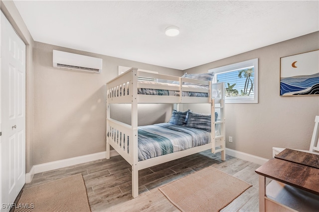 bedroom with a wall mounted AC and a closet