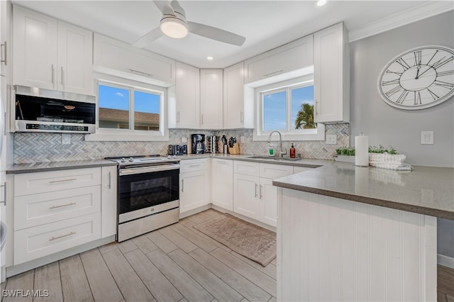 kitchen featuring sink, white cabinets, ceiling fan, kitchen peninsula, and stainless steel appliances