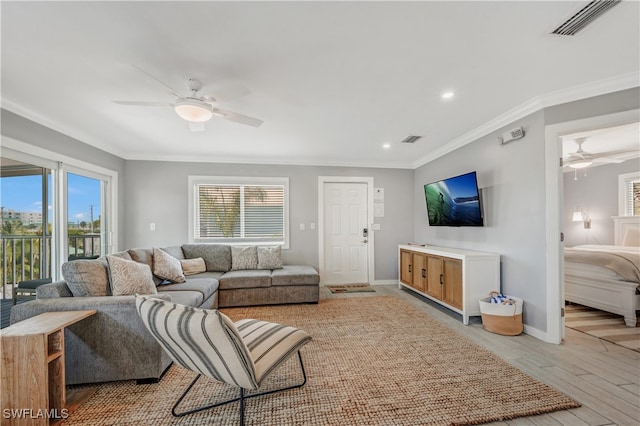 living room with crown molding, light hardwood / wood-style flooring, and ceiling fan