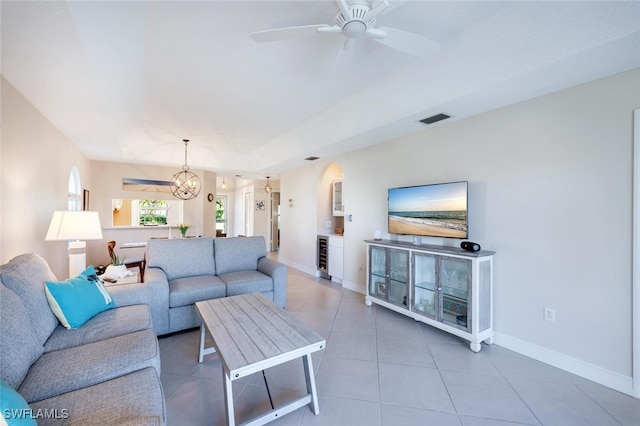 living room featuring ceiling fan with notable chandelier, wine cooler, and tile patterned floors