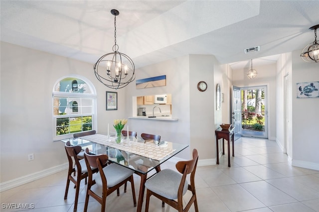 tiled dining space with sink and a chandelier