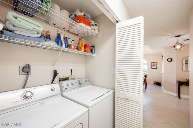 clothes washing area with washing machine and dryer and light tile patterned floors