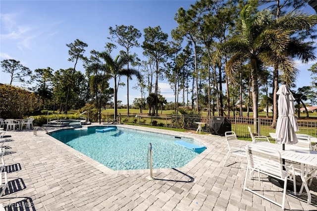 view of swimming pool with a hot tub, a patio, and grilling area