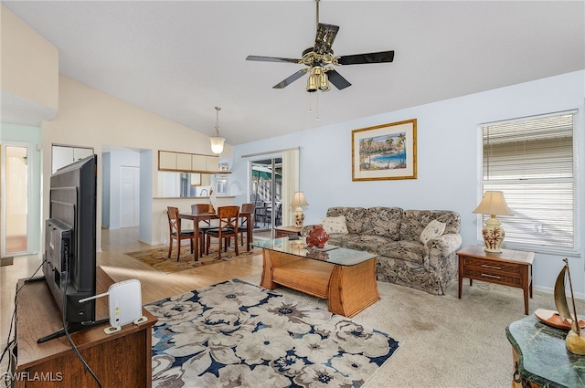 living room with ceiling fan, vaulted ceiling, and light carpet