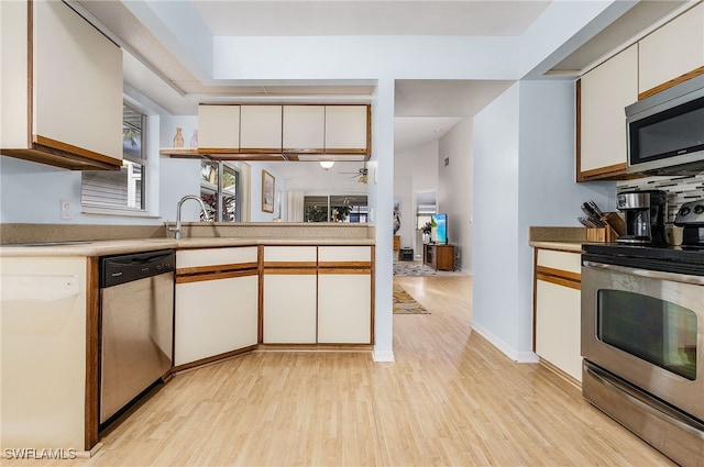 kitchen with white cabinetry, sink, light hardwood / wood-style flooring, and appliances with stainless steel finishes