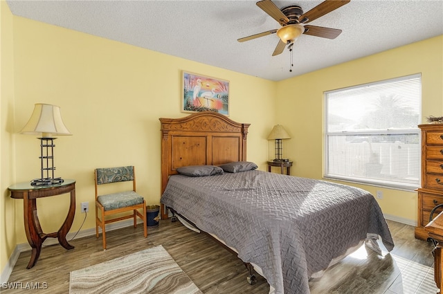 bedroom with wood-type flooring, a textured ceiling, and ceiling fan