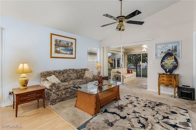 living room featuring ceiling fan, lofted ceiling, a textured ceiling, and light hardwood / wood-style floors