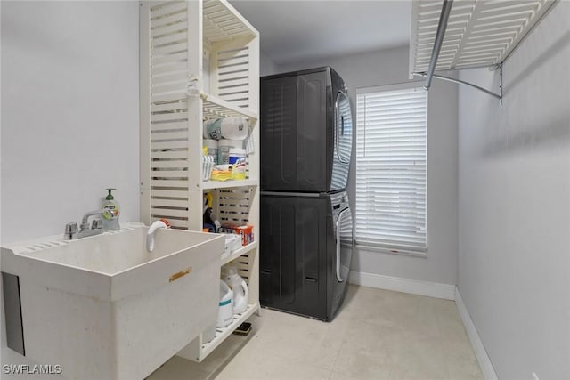 laundry area with stacked washer and dryer and sink