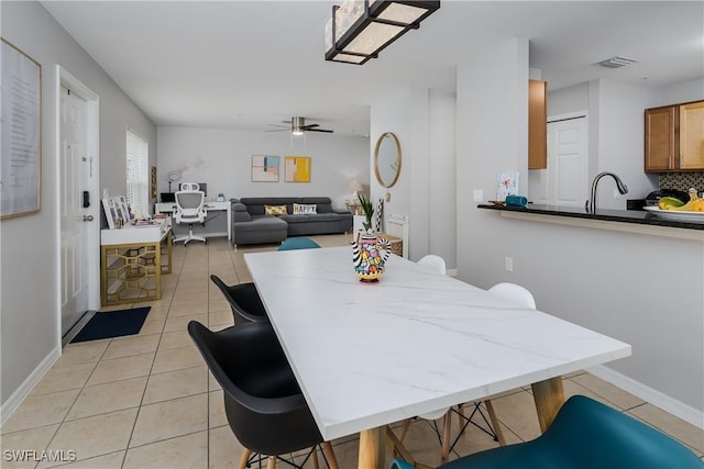 tiled dining space featuring sink and ceiling fan