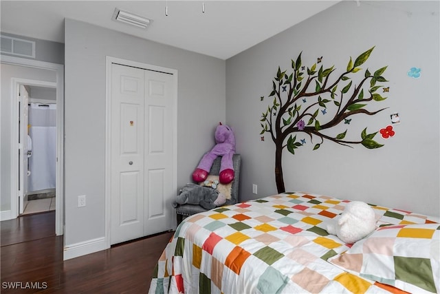 bedroom with dark hardwood / wood-style floors and a closet