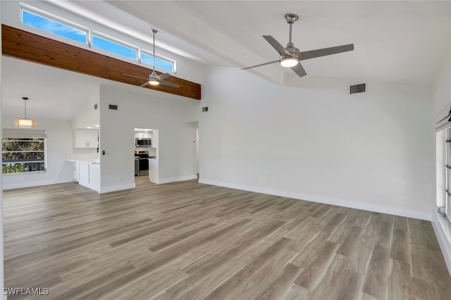 unfurnished living room with light hardwood / wood-style flooring, high vaulted ceiling, and ceiling fan