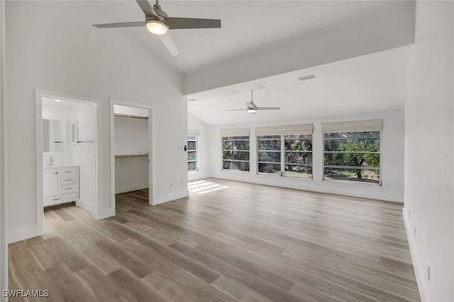 unfurnished living room with light hardwood / wood-style floors, high vaulted ceiling, and ceiling fan