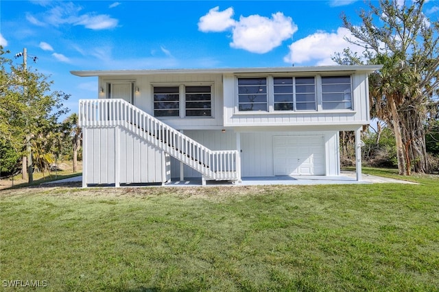 back of property with a garage and a lawn