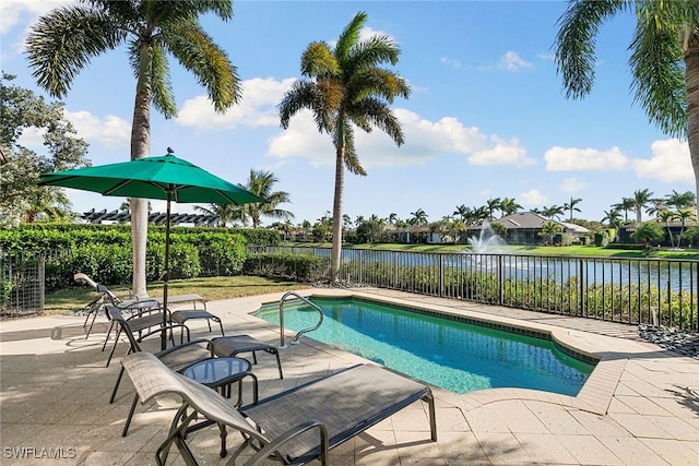 view of pool featuring a patio area, a water view, and a fenced backyard