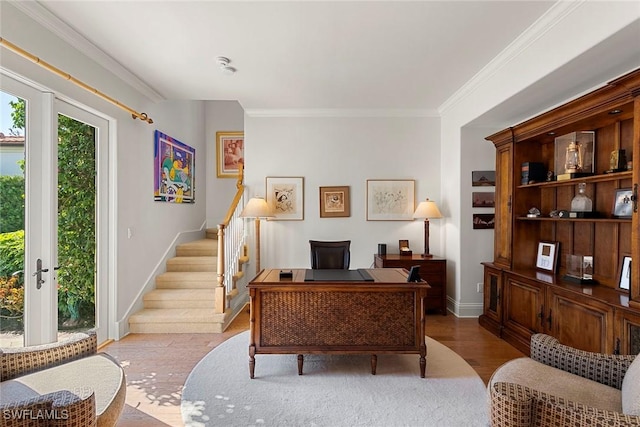 office area with light wood-style flooring, ornamental molding, and baseboards