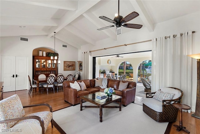 living area with beam ceiling, visible vents, ceiling fan, and wood finished floors