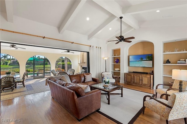 living area with vaulted ceiling with beams, ceiling fan, hardwood / wood-style floors, and built in features