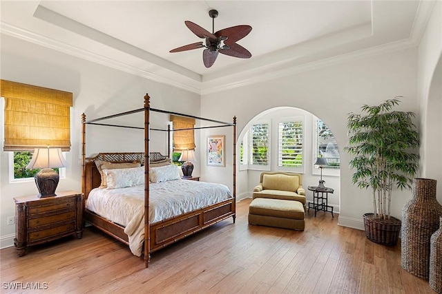 bedroom featuring a tray ceiling, crown molding, and hardwood / wood-style floors