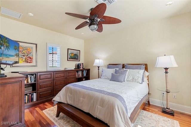 bedroom with ceiling fan, light wood-type flooring, visible vents, and baseboards