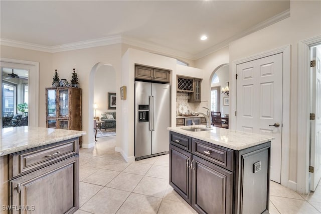 kitchen featuring an island with sink, sink, high end refrigerator, and light tile patterned floors