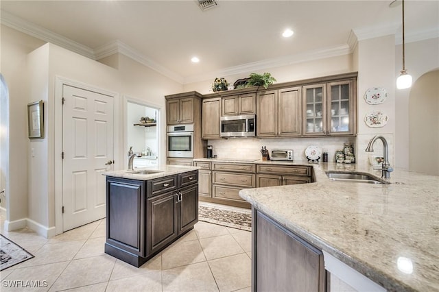 kitchen featuring stainless steel appliances, sink, decorative backsplash, and kitchen peninsula