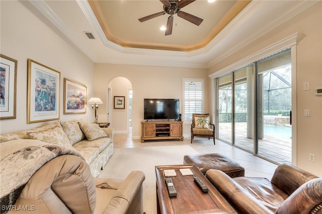 living room featuring ornamental molding, a raised ceiling, and ceiling fan