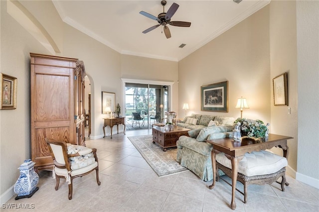 living room featuring light tile patterned floors, a towering ceiling, and ornamental molding