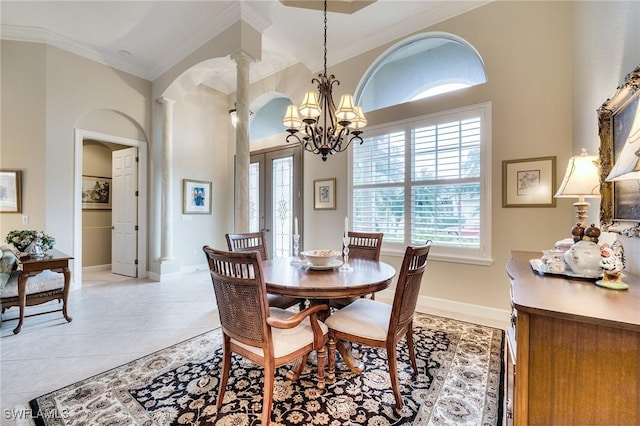 tiled dining space with french doors, ornamental molding, a chandelier, and ornate columns