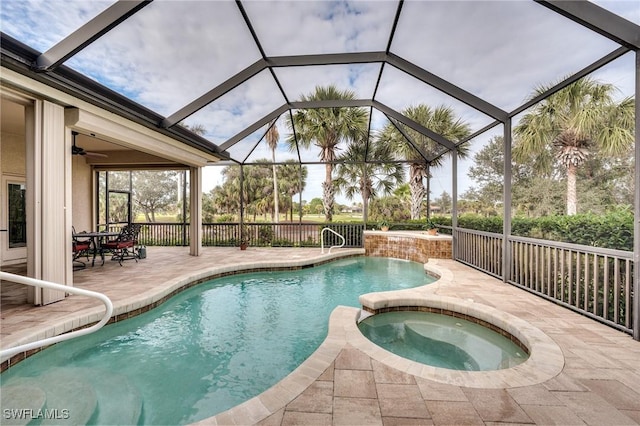 view of pool with ceiling fan, a patio, glass enclosure, and an in ground hot tub