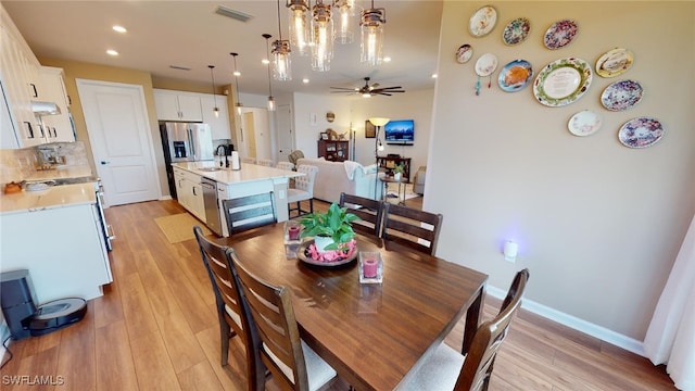 dining room with sink, light hardwood / wood-style floors, and ceiling fan