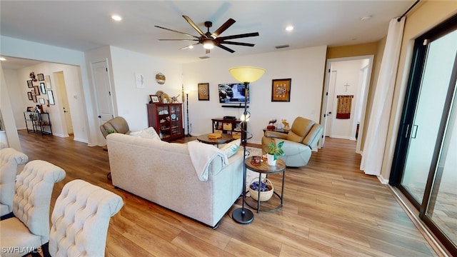 living room featuring ceiling fan and light wood-type flooring