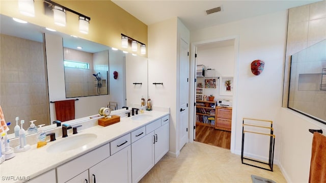 bathroom with walk in shower, vanity, and tile patterned flooring