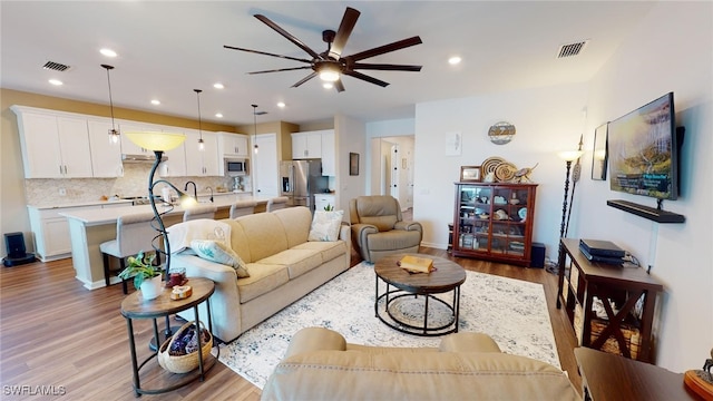 living room featuring light hardwood / wood-style floors and ceiling fan