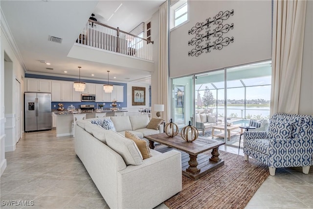 tiled living room featuring a wealth of natural light, a high ceiling, and crown molding