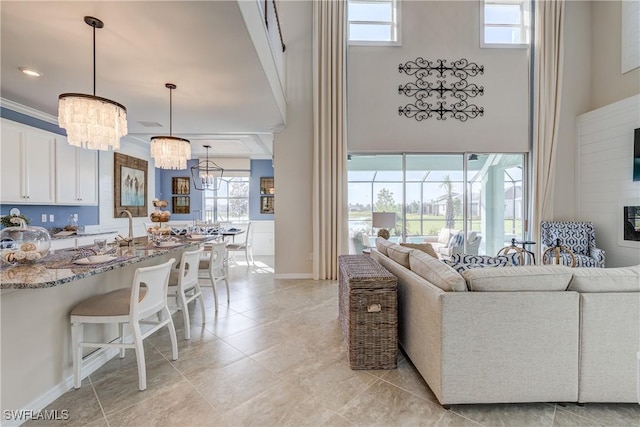 living room with ornamental molding and an inviting chandelier