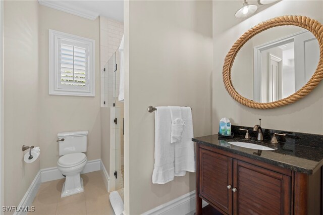 bathroom featuring tile patterned flooring, vanity, toilet, and walk in shower