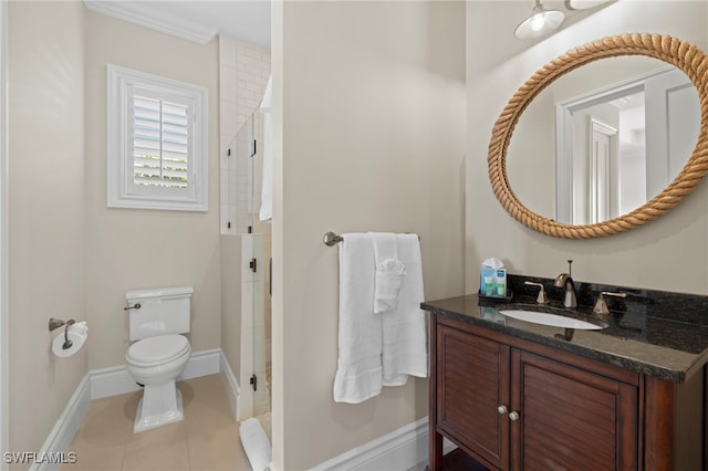 bathroom with toilet, a shower stall, vanity, tile patterned flooring, and baseboards