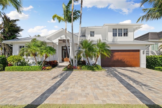 view of front of home featuring an attached garage, stucco siding, driveway, and french doors