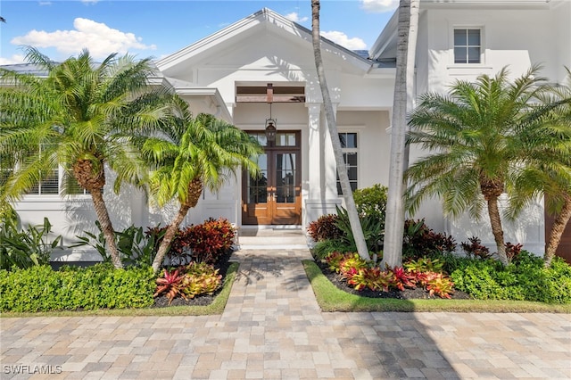 doorway to property featuring french doors and stucco siding