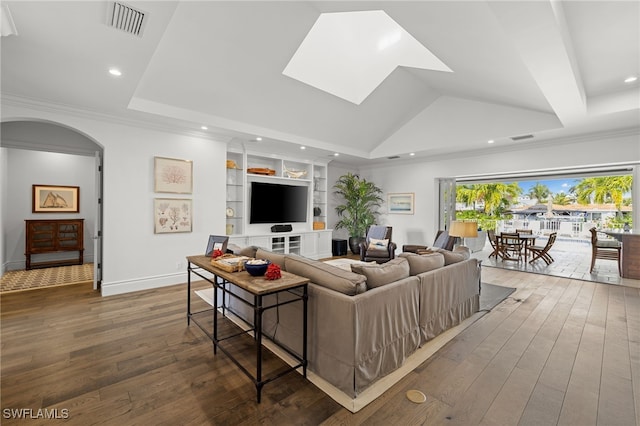 living room with arched walkways, visible vents, a raised ceiling, hardwood / wood-style floors, and built in shelves